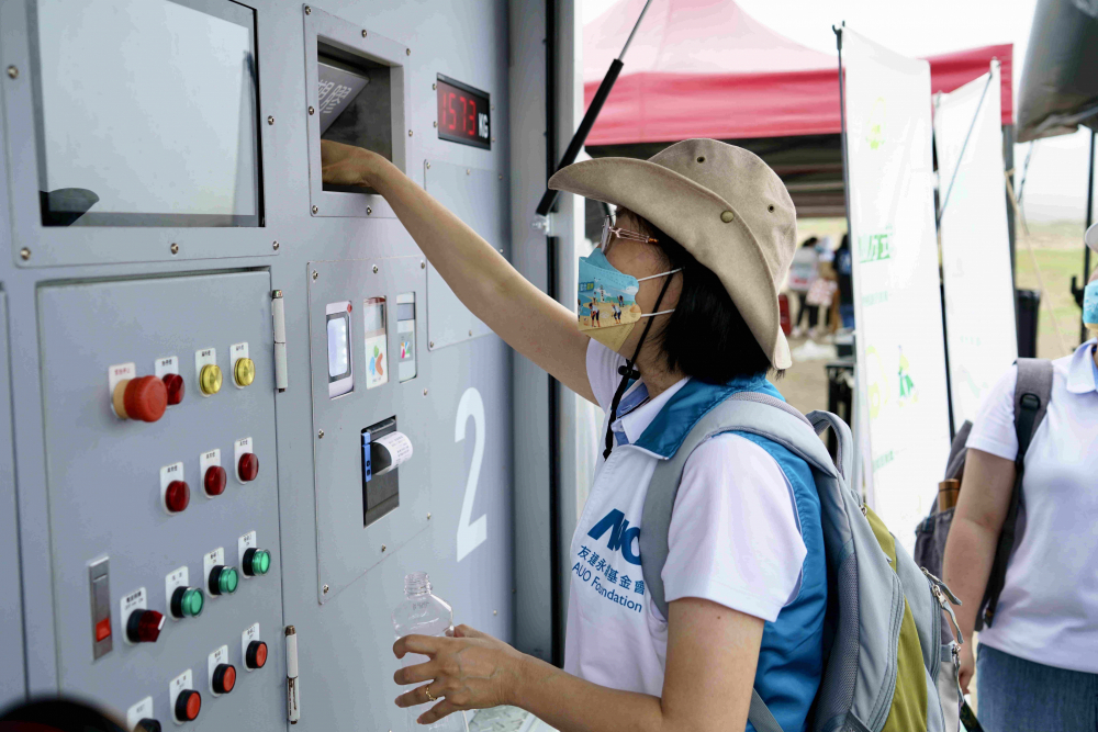 志工們將拾起的寶特瓶投入「好歸塑專車」，讓廢棄塑料空瓶可以直接粉碎、縮小體積，未來將可再製成購物袋、寶特衣、悠遊卡等生活用品