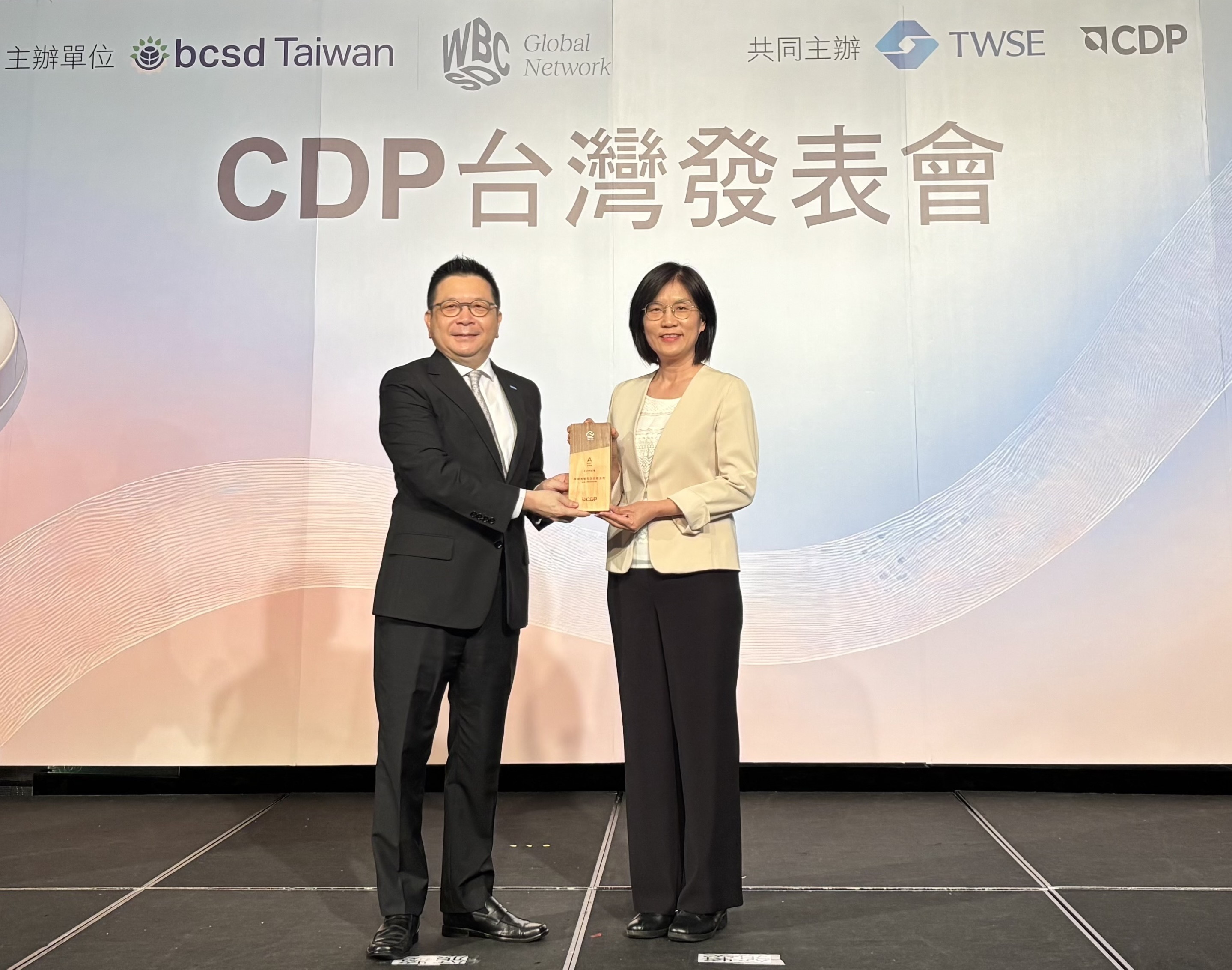 友達永續成果再獲國際評比肯定，獲頒CDP氣候與水資源雙項領導力評級。今由臺灣證券交易所董事長林修銘（左）頒獎，友達光電永續長古秀華（右）代表受獎